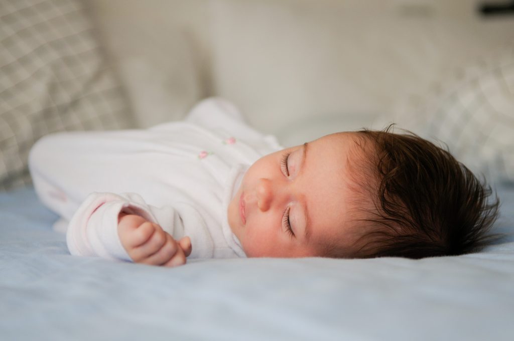 newborn baby girl sleeping blue sheets home (1)